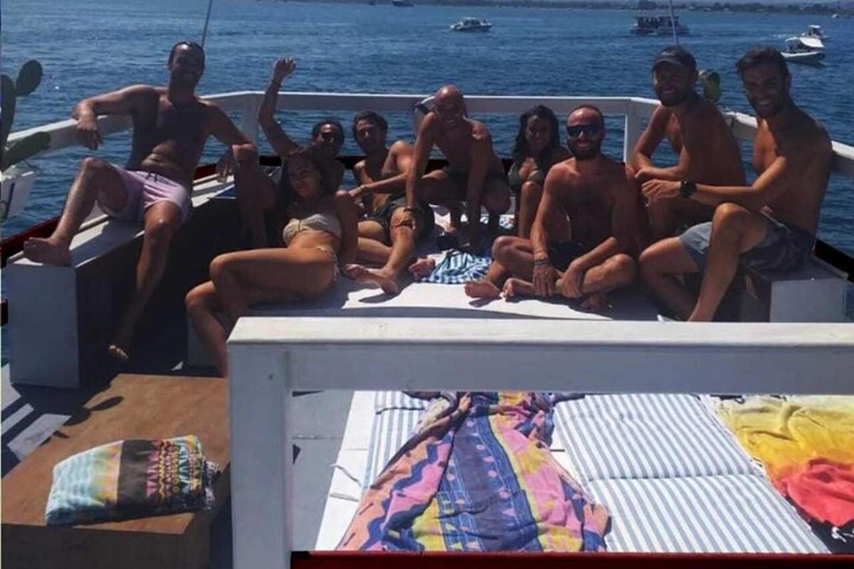 un gruppo di persone sedute sul retro di una barca