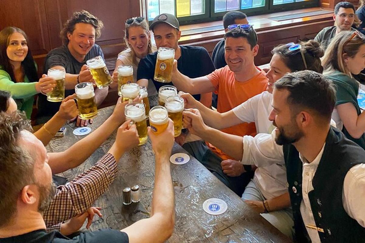 eine Gruppe von Menschen sitzt um einen Tisch und trinkt Bier