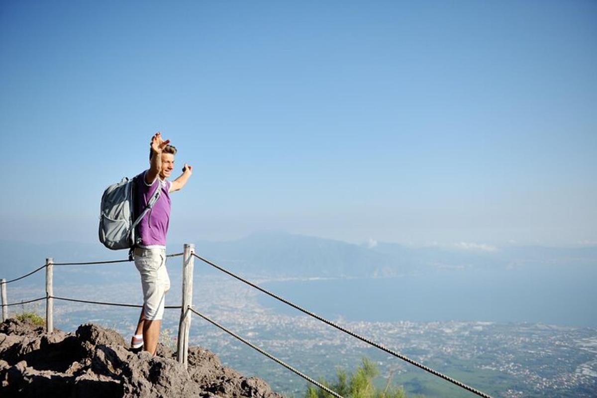 isang lalaking may backpack na nakatayo sa tuktok ng bundok
