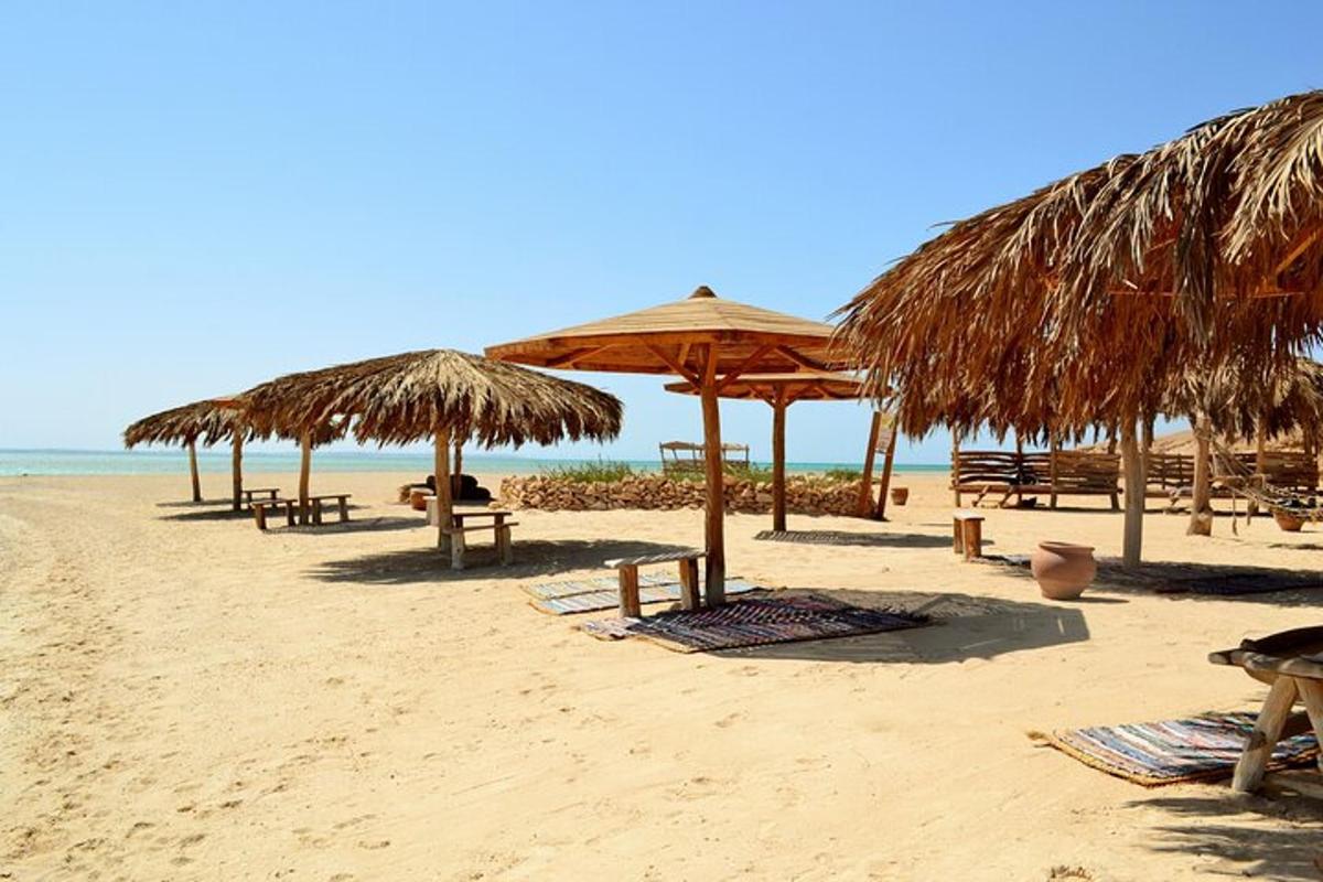 plaža z mizami, slamnatimi senčniki in stoli