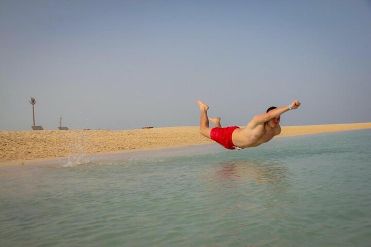 رجل يقفز في الماء على الشاطئ