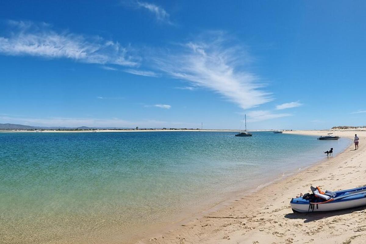 a beach with a boat on the sand and water