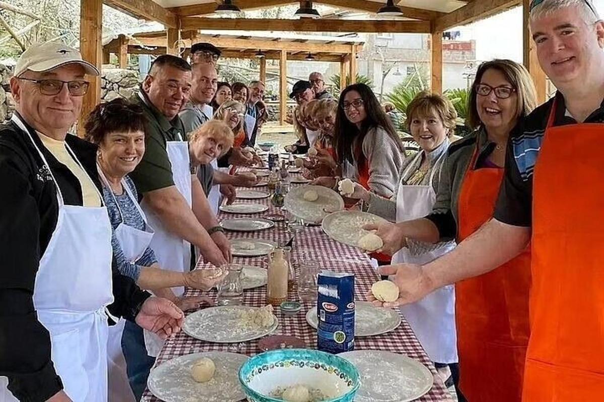 skupina lidí stojící kolem dlouhého stolu