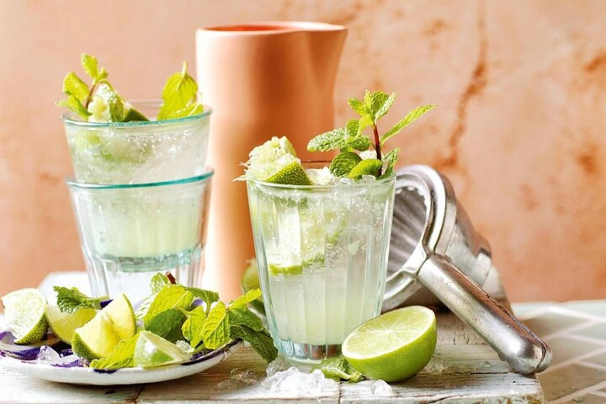 two glasses filled with lime and mint on a table