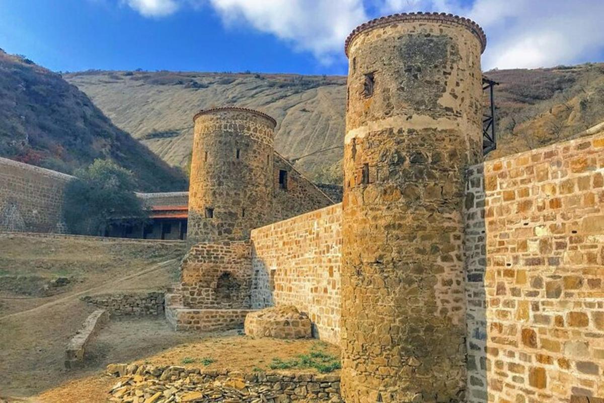 two stone towers sitting next to a brick wall
