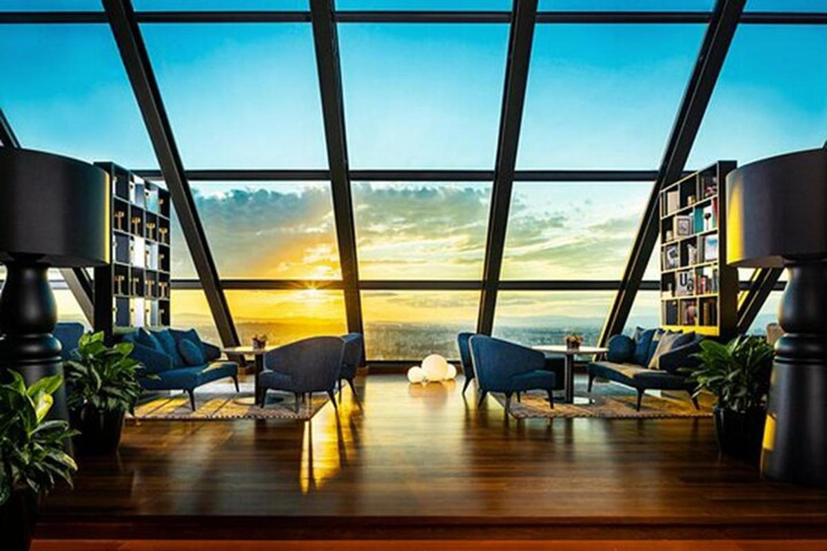 uma sala grande com uma janela grande com cadeiras e livros