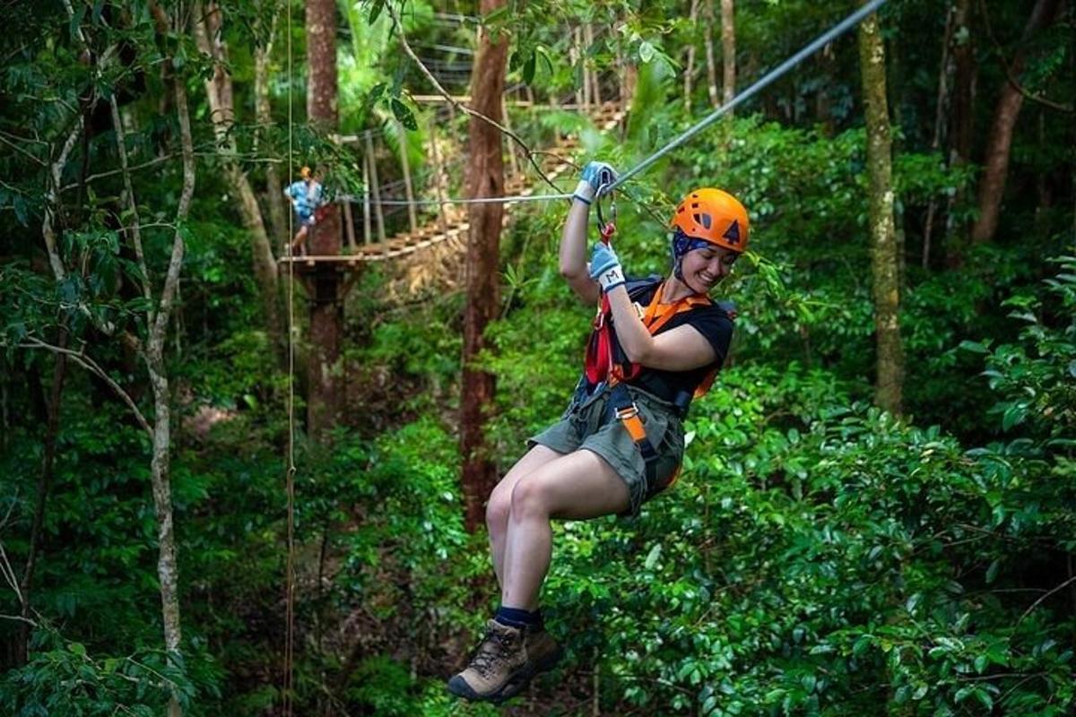 a man on a zip line in the forest