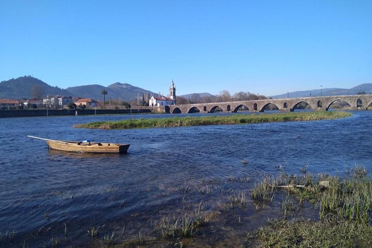 o barcă pe un râu cu un pod în fundal