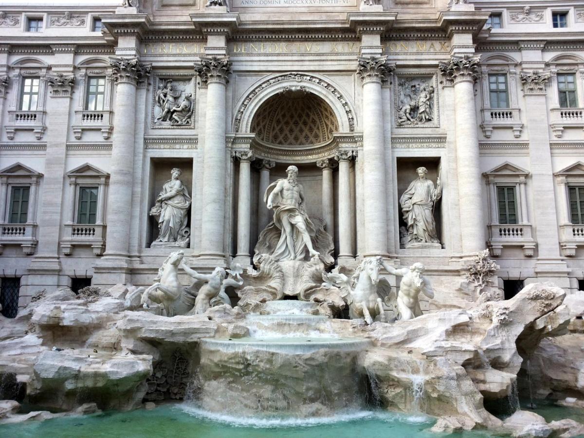 a fountain in front of a building with statues