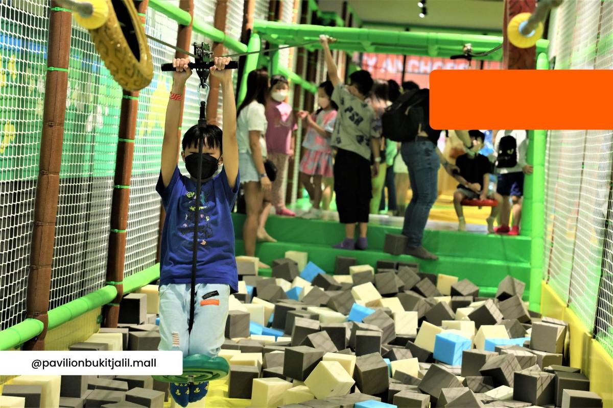 a young boy is climbing in a play gym