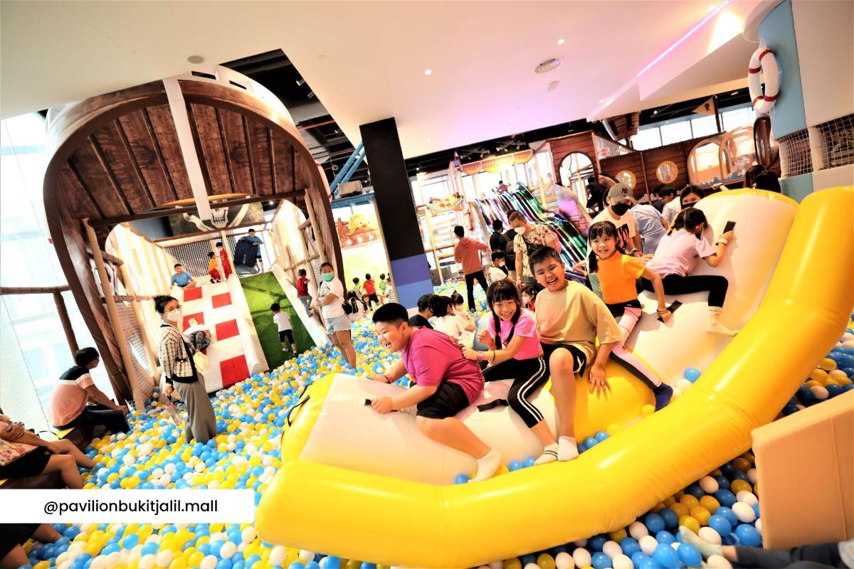 a group of people playing in an indoor play gym