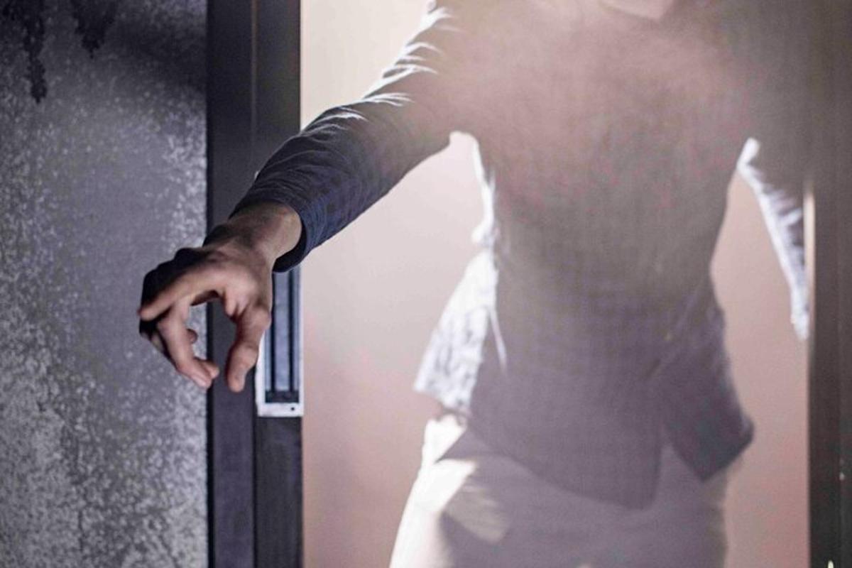 un hombre abriendo una puerta con la mano extendida