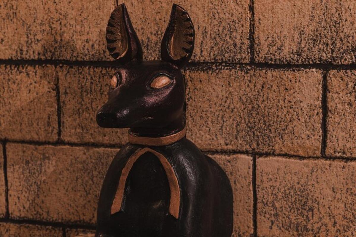 en svart statue av en kanin på en murvegg