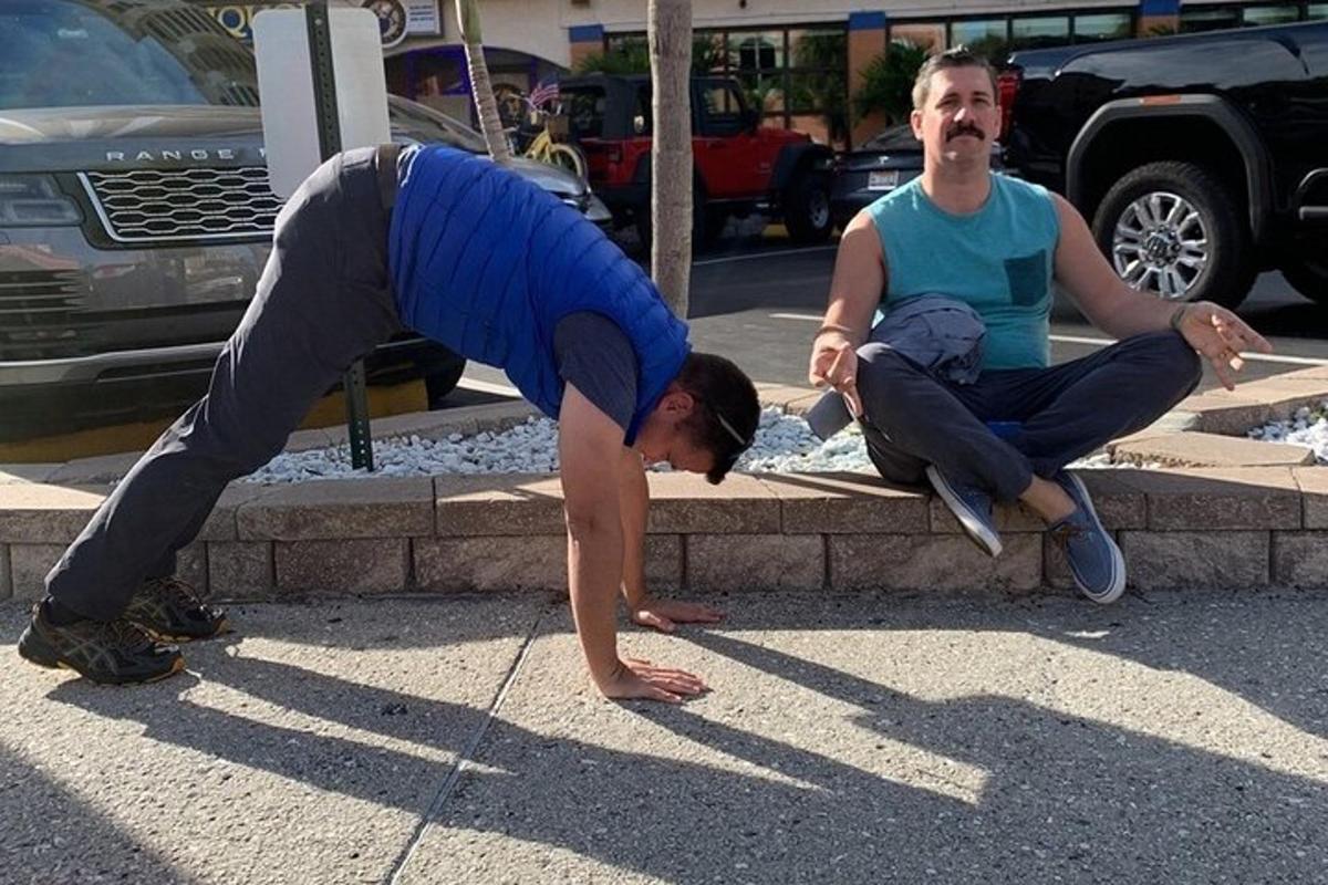 um homem fazendo parada de mão na frente de outro homem