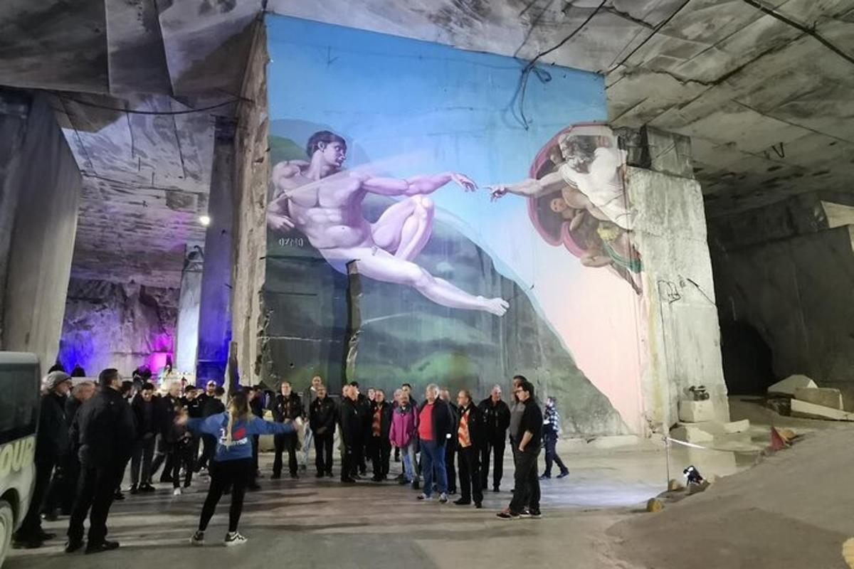 un grup de persones dempeus davant d'un gran mural
