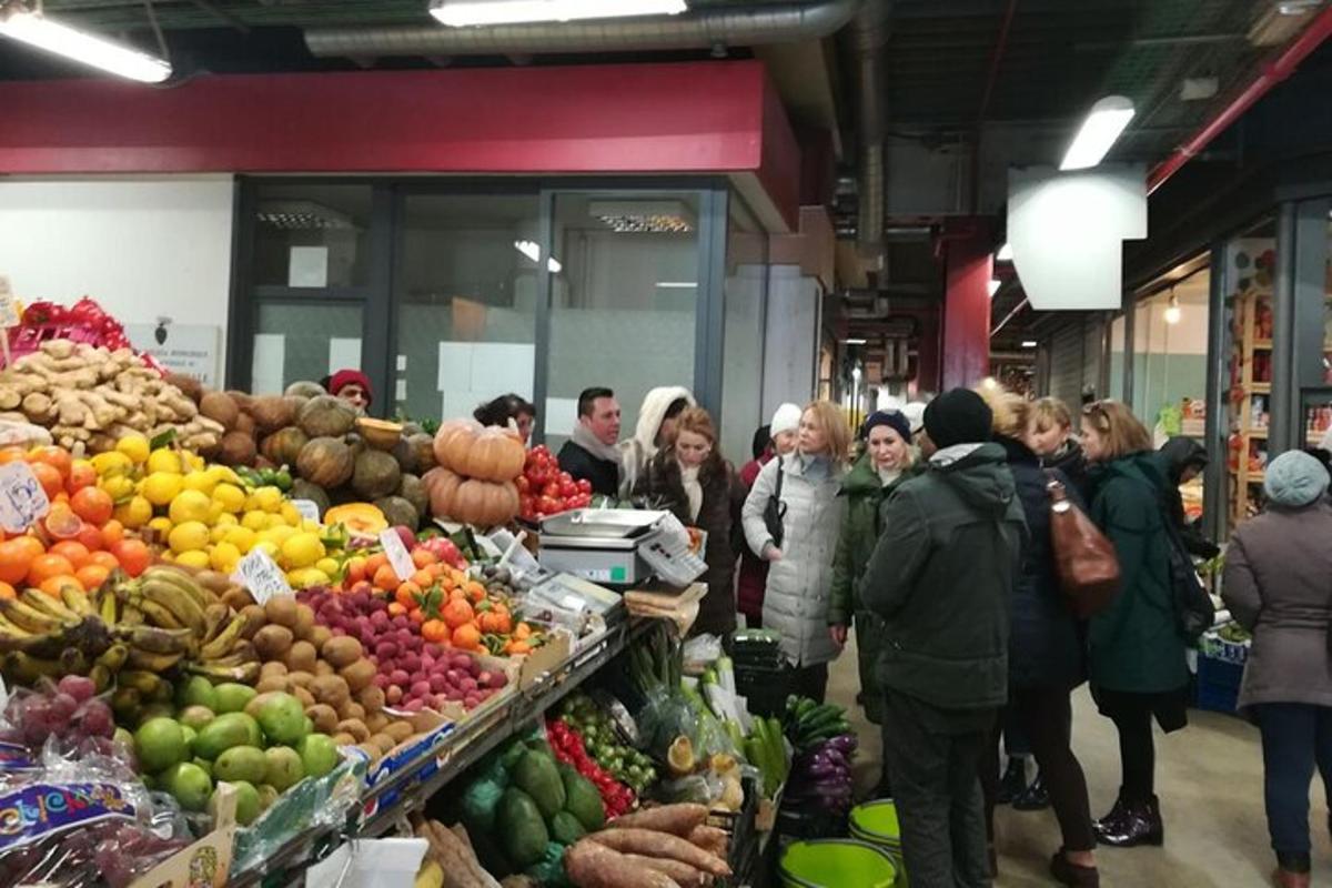 un grup de oameni care stăteau în jurul unei piețe de fructe