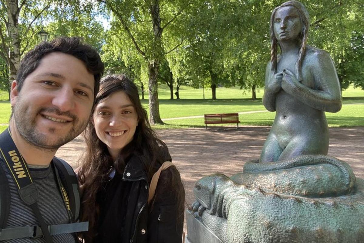 un uomo e una donna in piedi accanto a una statua