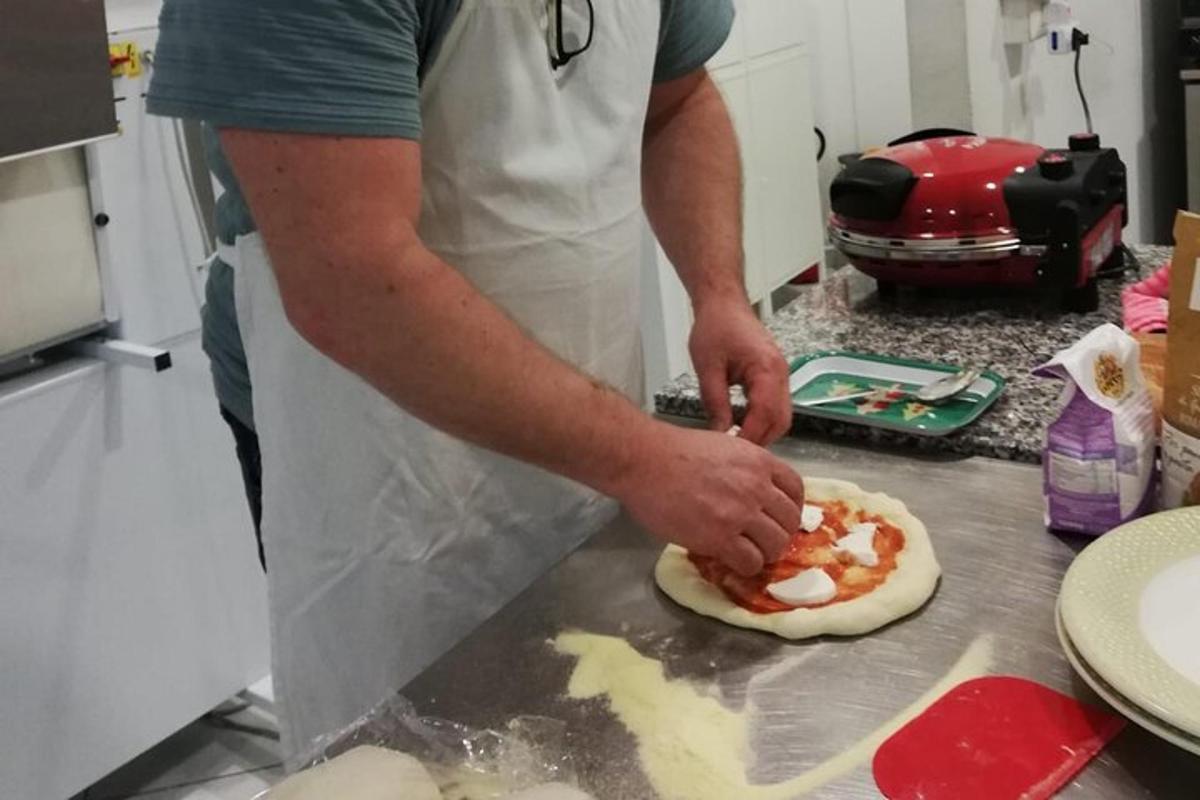 en mann på kjøkkenet som lager pizza