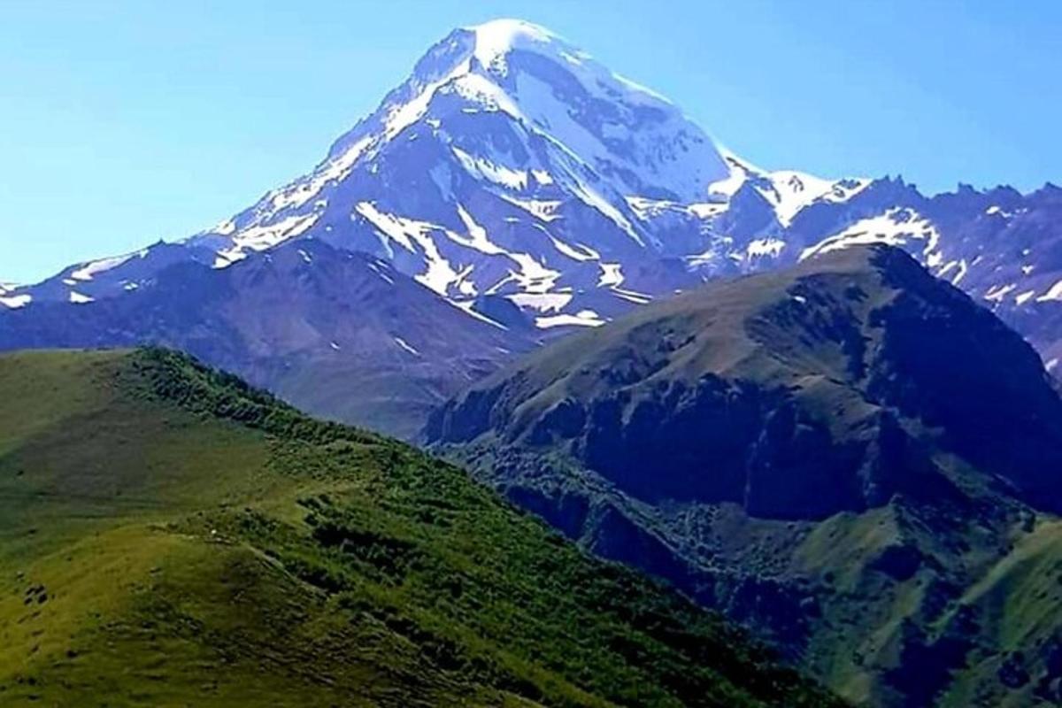 una montagna innevata con una montagna verde