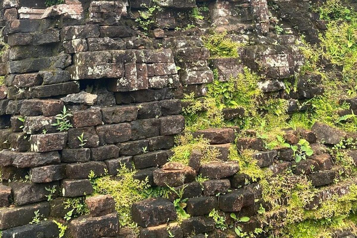 an old stone wall with grass and weeds