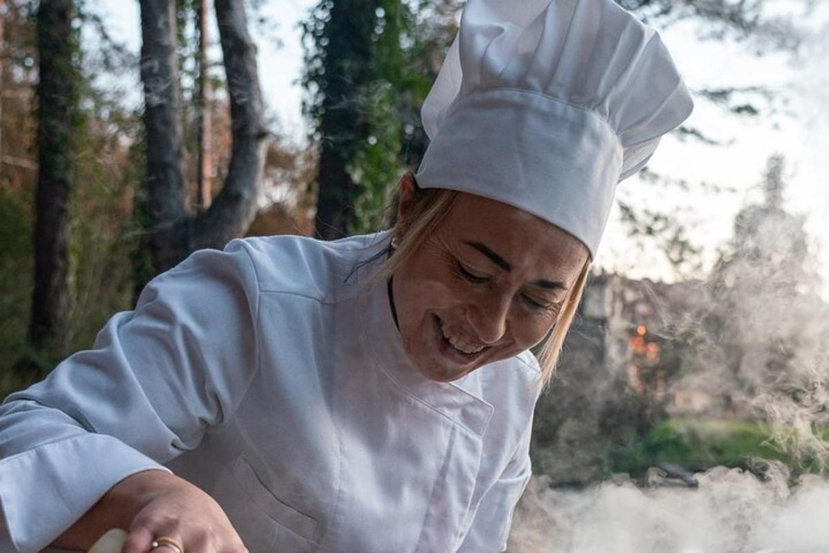seorang wanita berpakaian chef memotong makanan