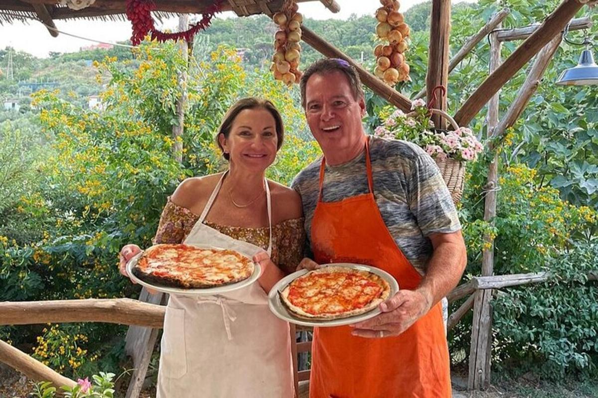 muž a žena držící dva talíře pizzy