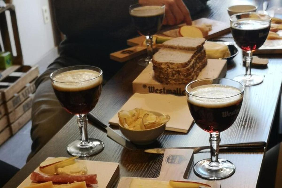 una taula coberta amb dos gots de cervesa i patates fregides