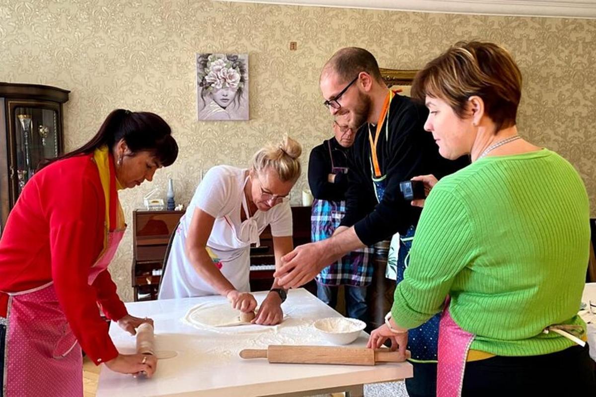 skupina lidí stojících kolem stolu a připravujících jídlo