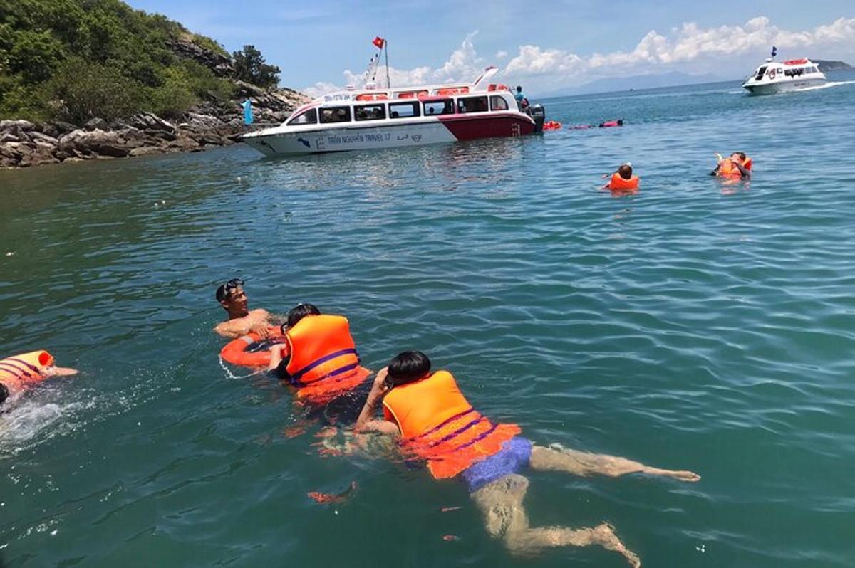 un gruppo di persone in acqua con una barca