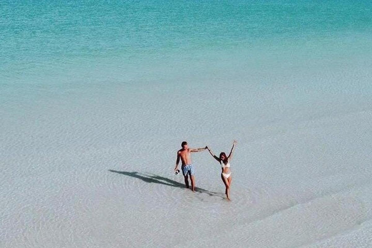 un uomo e una donna che camminano sulla spiaggia
