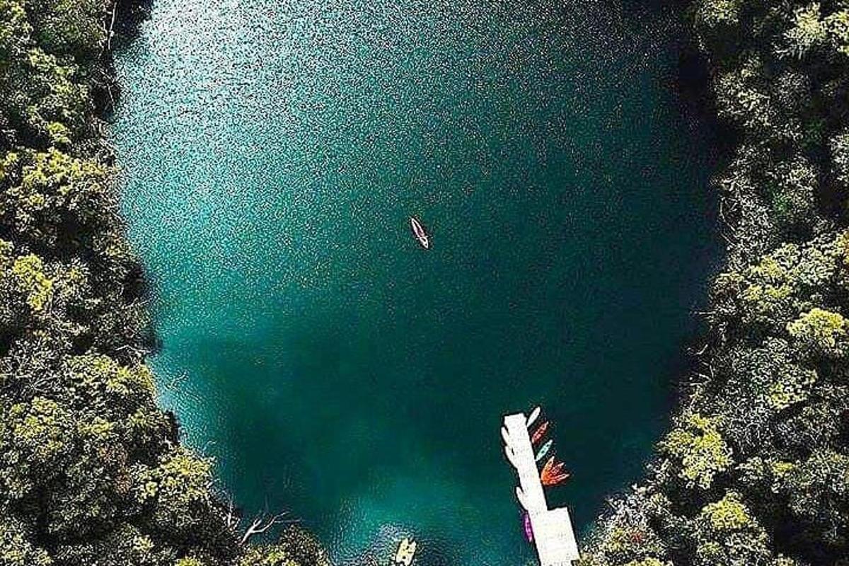 una vista aerea di un lago con una barca al suo interno