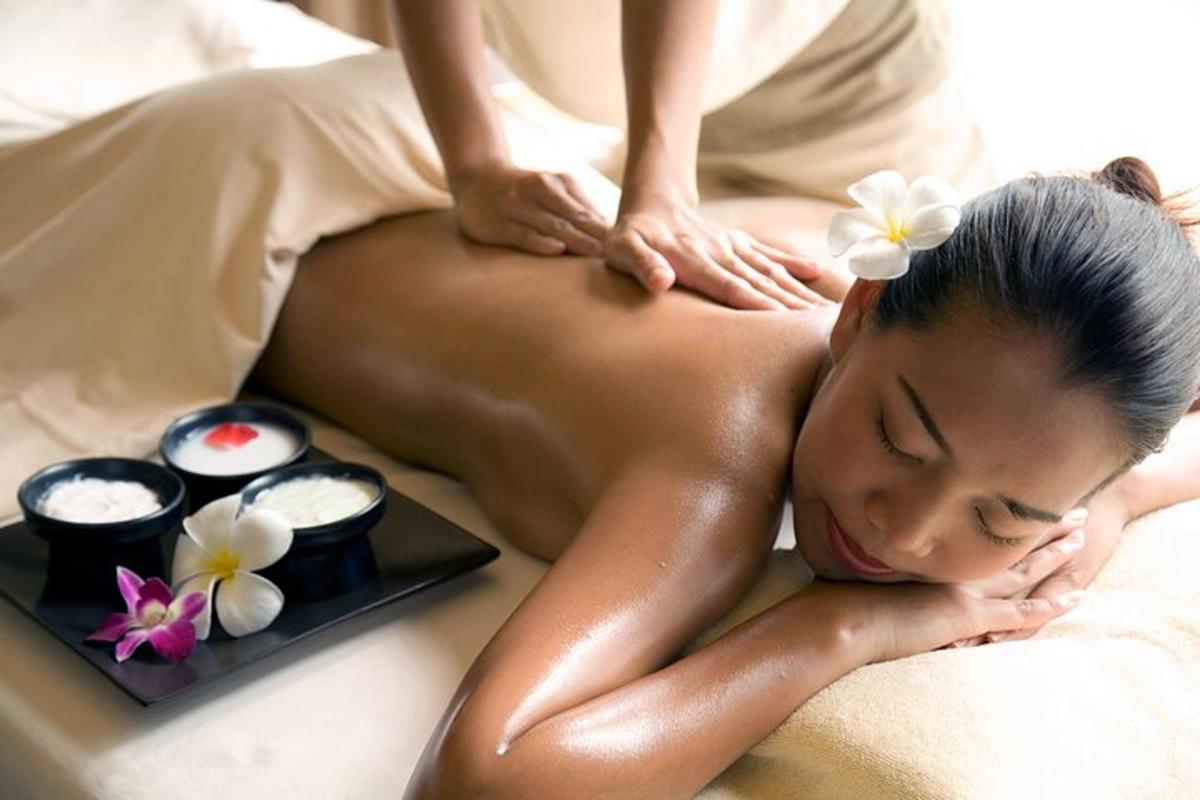 a woman getting a massage in a spa with two candles