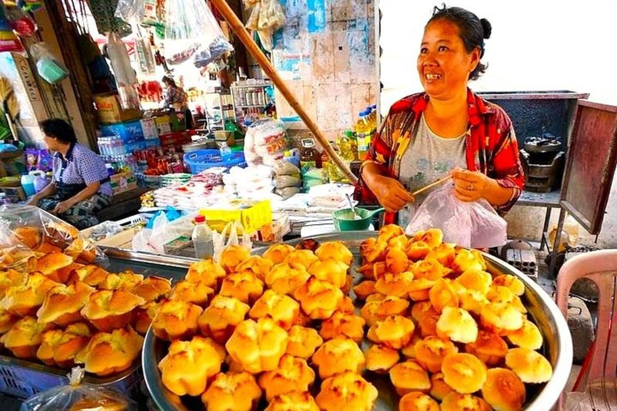 una dona dreta en un mercat amb un munt de taronges