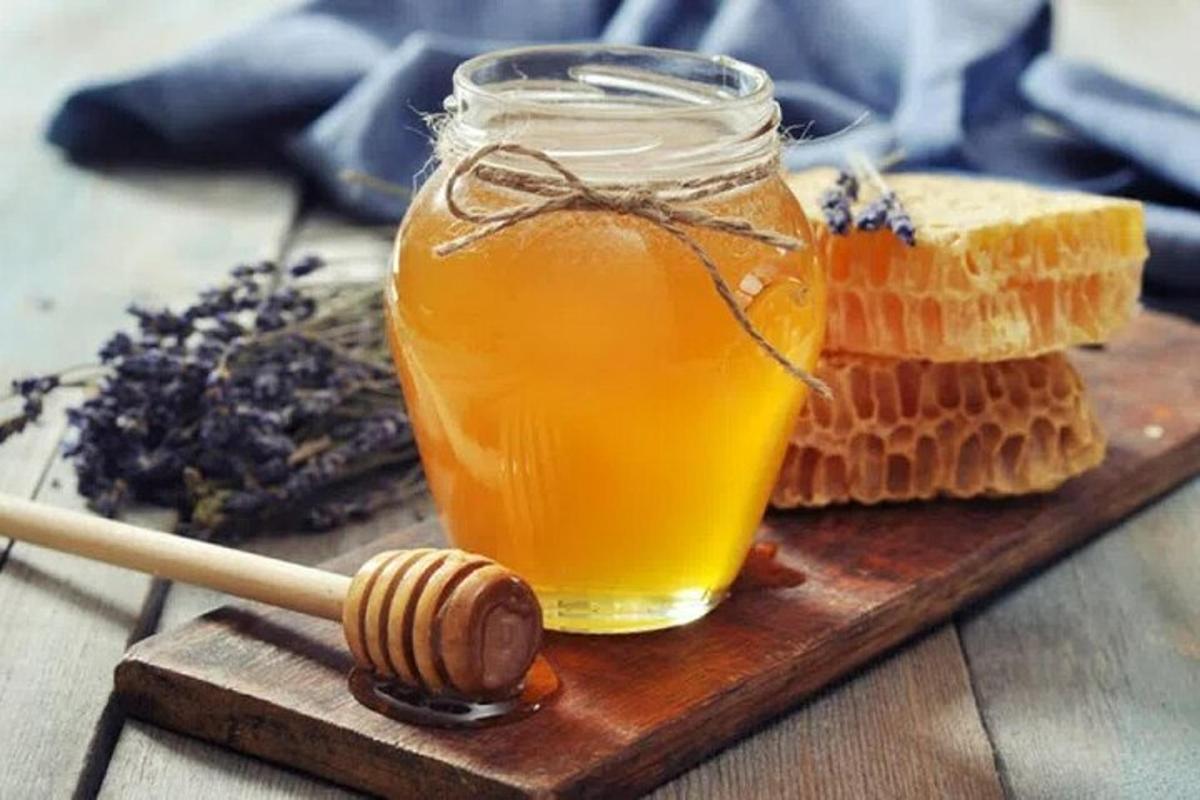 một lọ mật ong và bánh mì và một que mật ong