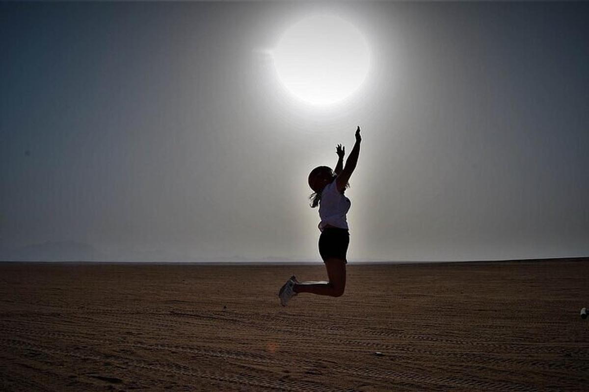 una donna che salta in mezzo al deserto