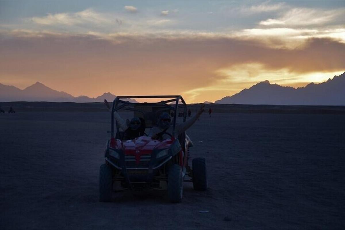 Dos personas viajando en un coche de juguete en el desierto.
