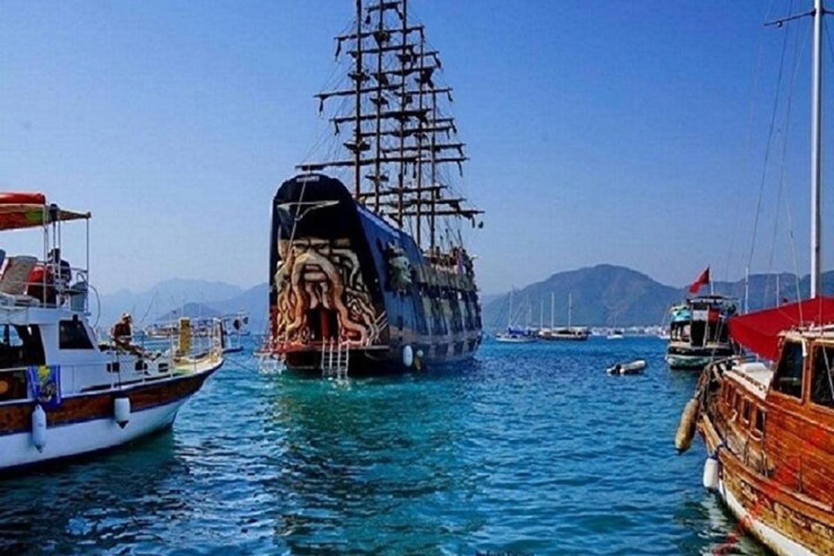 a large boat in the water next to other boats