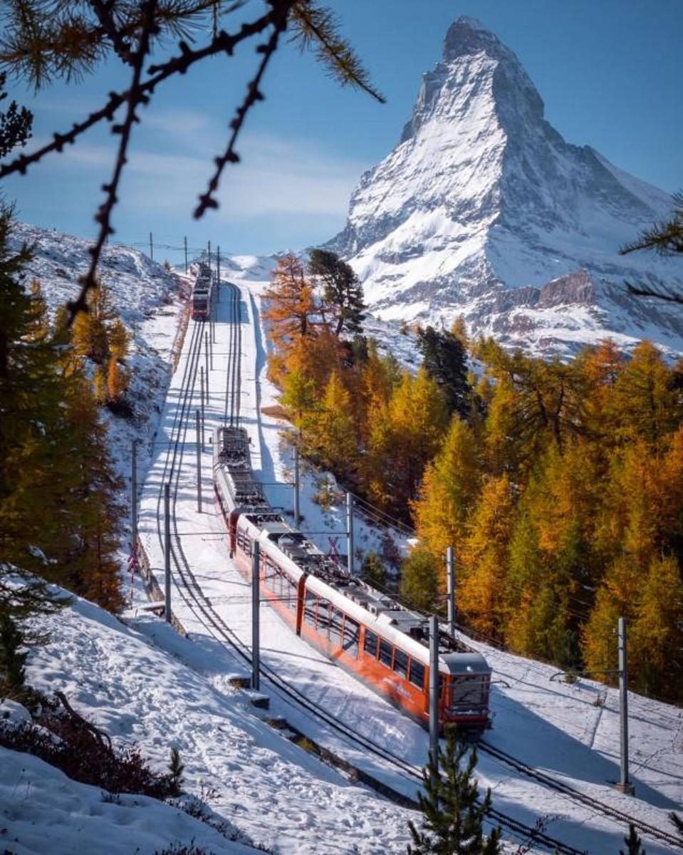 a train on the tracks in front of a mountain