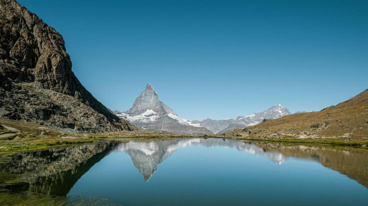 a mountain reflecting in a lake in the mountains