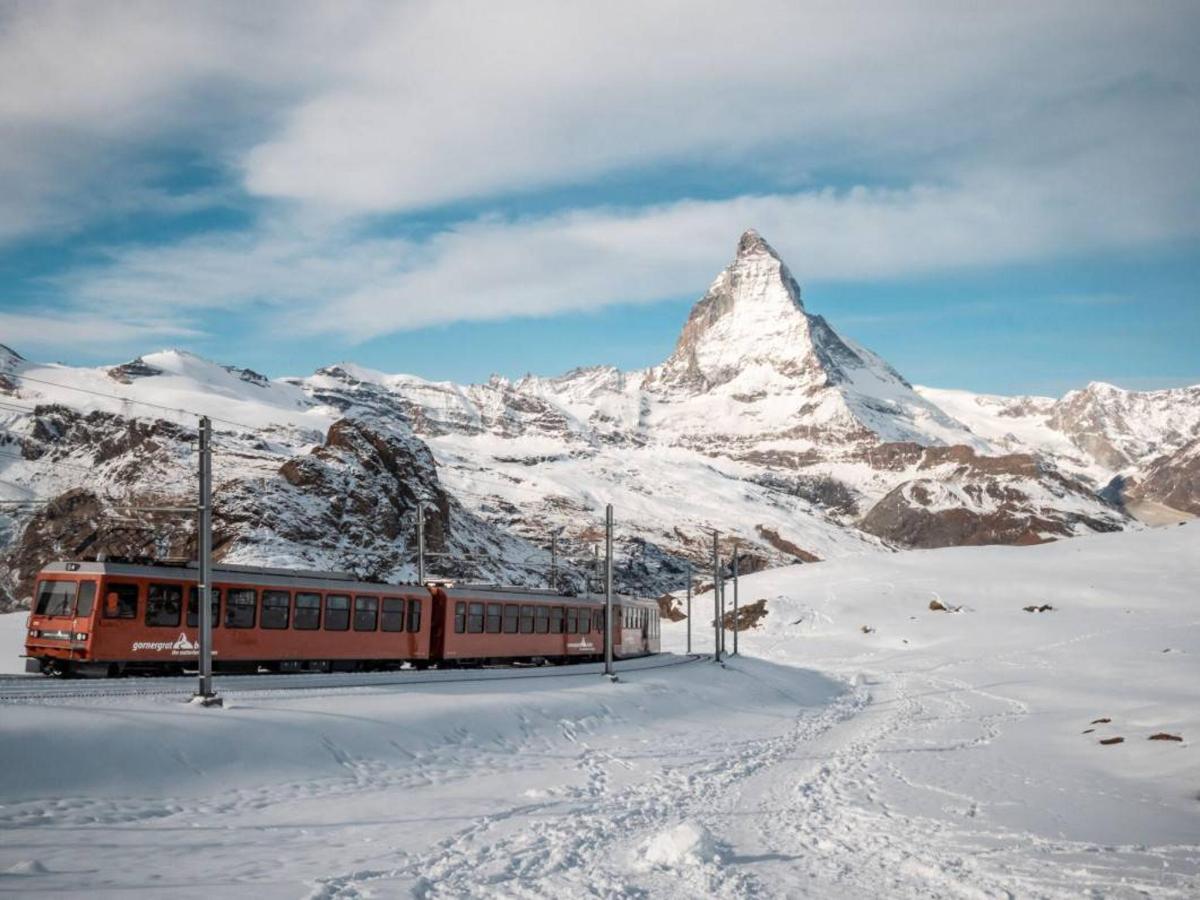 a train in front of a snow covered mountain