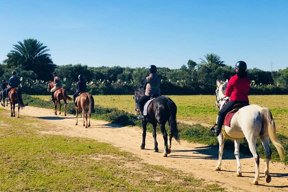 un gruppo di persone a cavallo su una strada sterrata