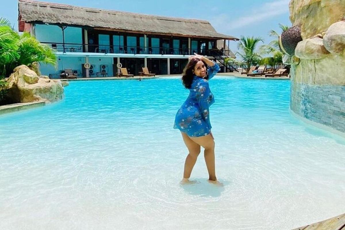 a woman standing in the water near a swimming pool