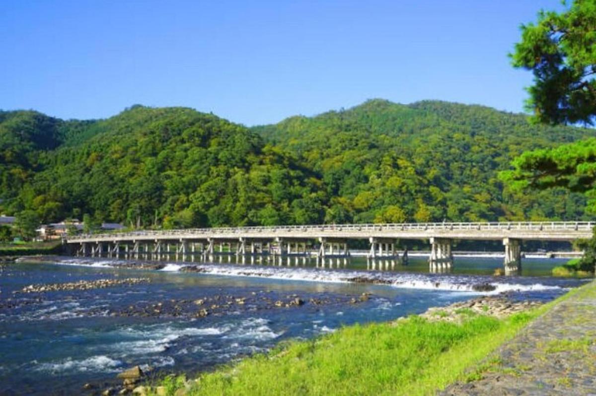 a bridge over a river with mountains in the background
