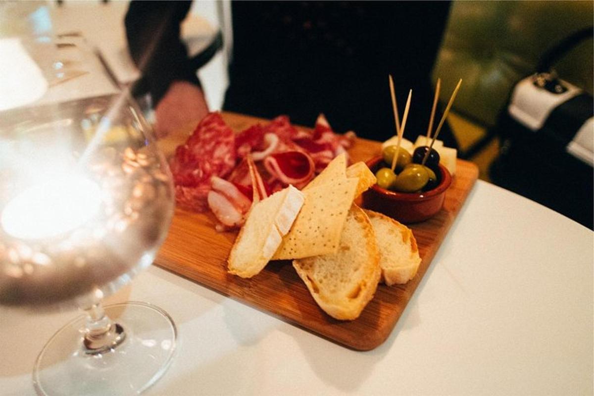 un piatto di cibo su un tavolo accanto a un bicchiere di vino
