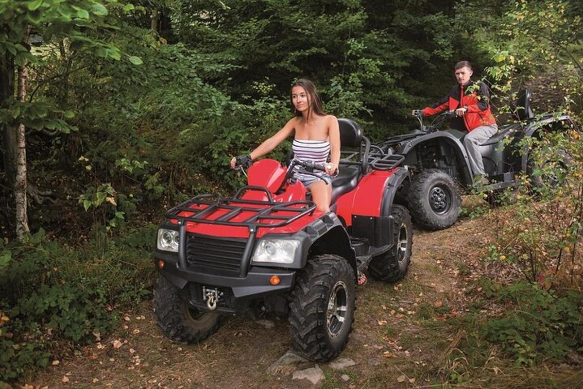 un uomo e una donna in sella a un quad su un sentiero