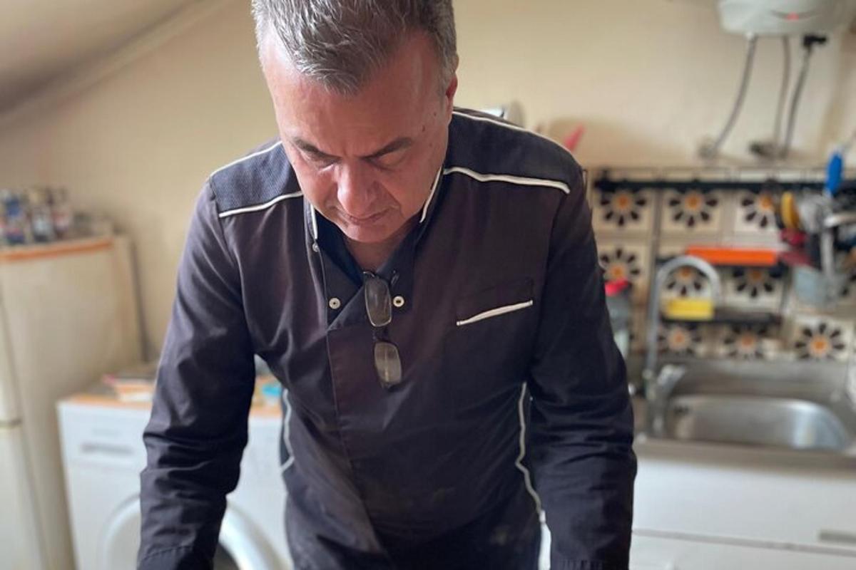un uomo in piedi in cucina che guarda qualcosa