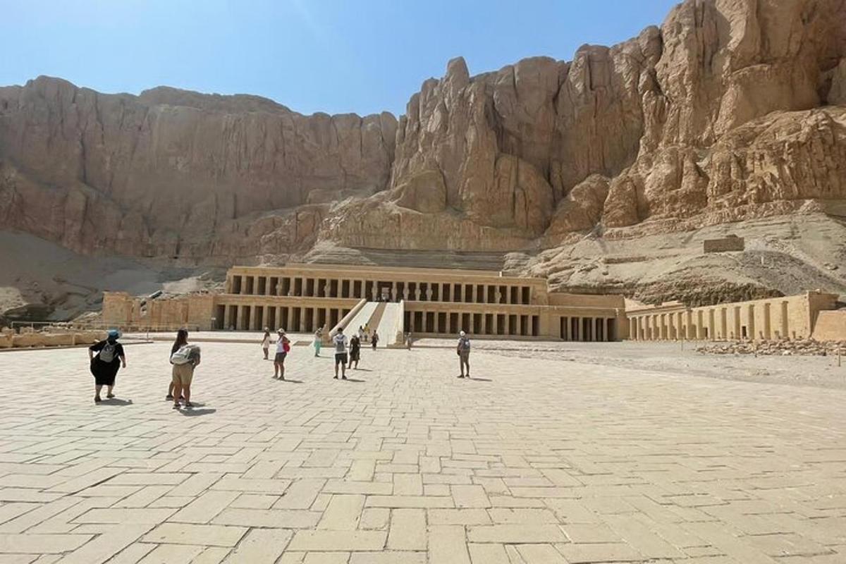 Un grupo de personas caminando alrededor de un edificio en el desierto.
