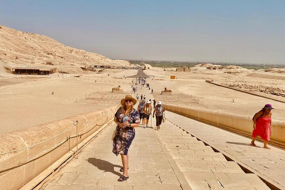 Una mujer caminando al costado de un muro cerca de una playa.