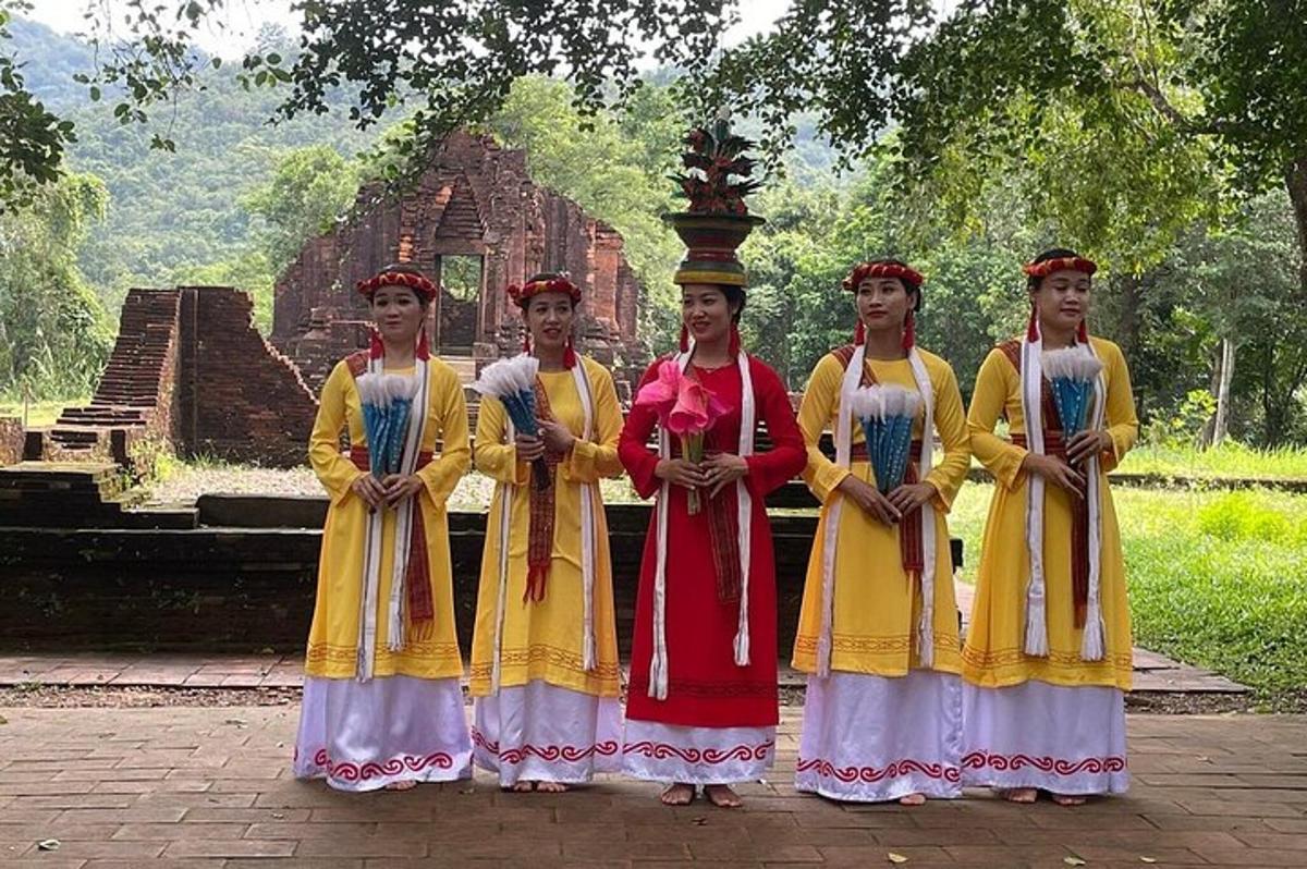 four girls in traditional dress standing in front of a building