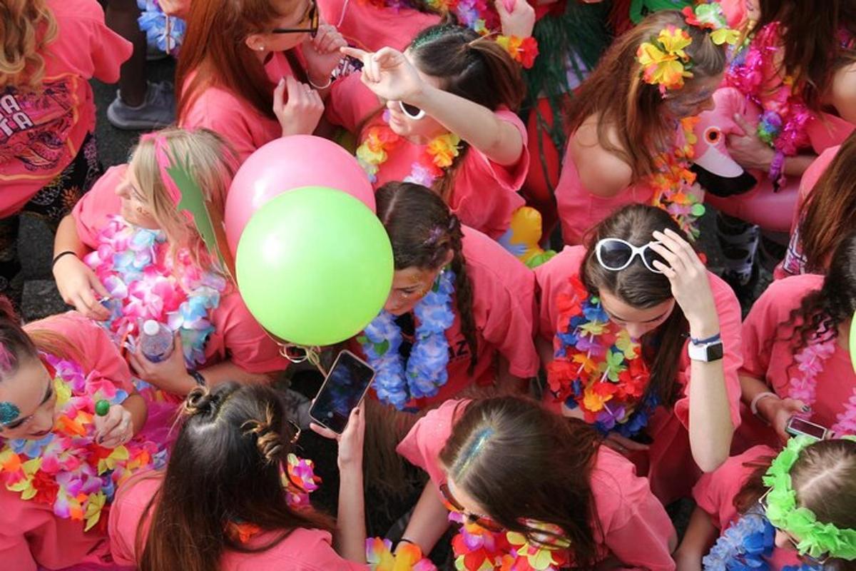 một nhóm các cô gái mặc áo sơ mi hồng với một quả bóng bay màu xanh lá cây